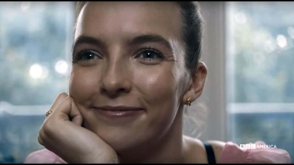Jodie Comer as Villanelle from Killing Eve, smiling mischieviously 