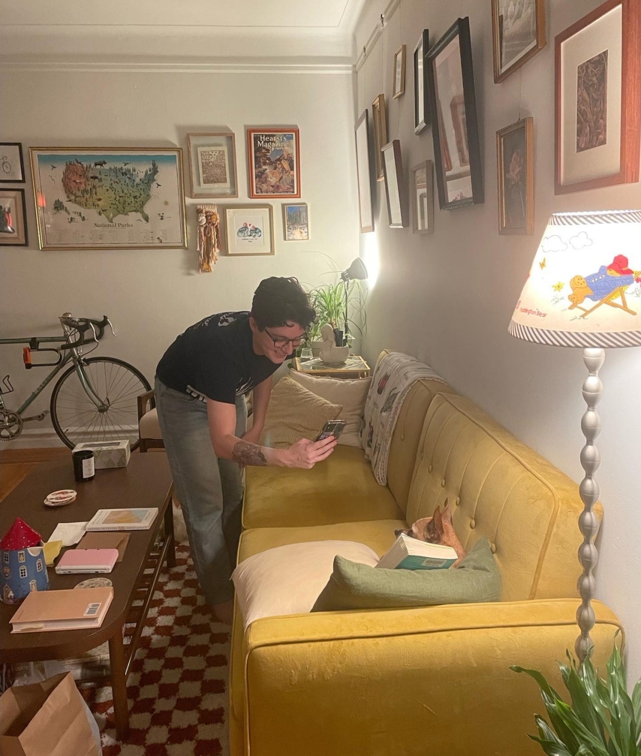 Nadine Santoro taking a photo of her dog, Knives the Chihuahua, on the couch with a straight romance novel.